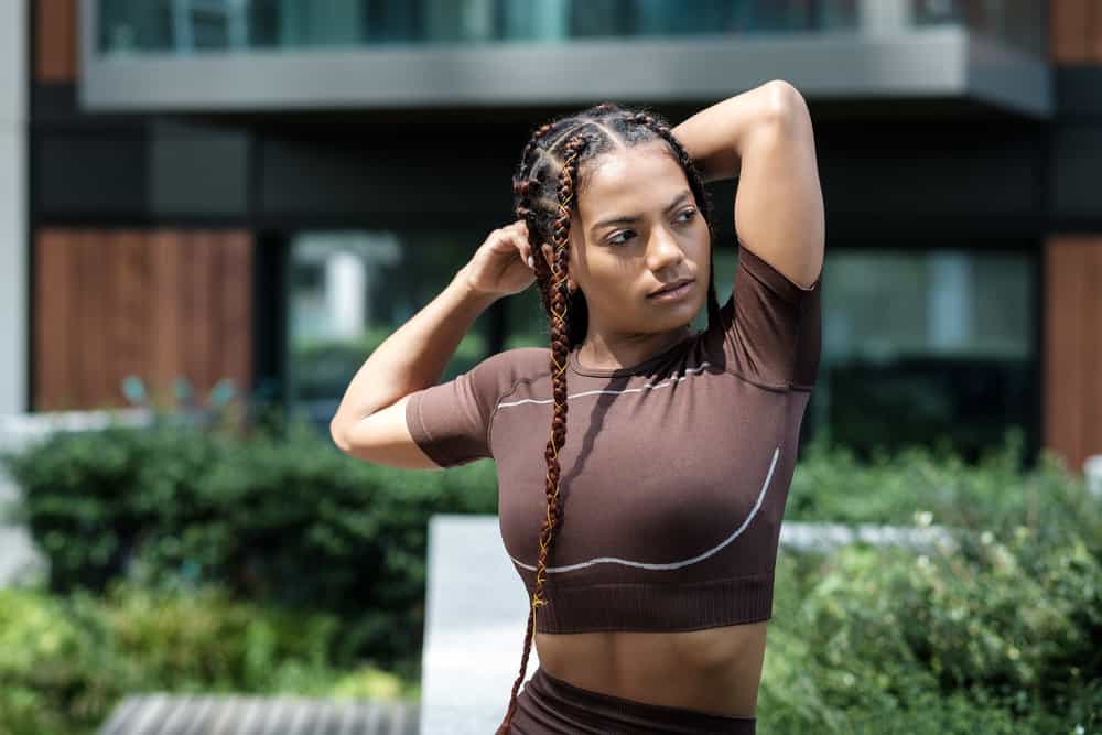 A mixed-race female preparing to work wearing unique micro braids where the individual braids resemble box braids.