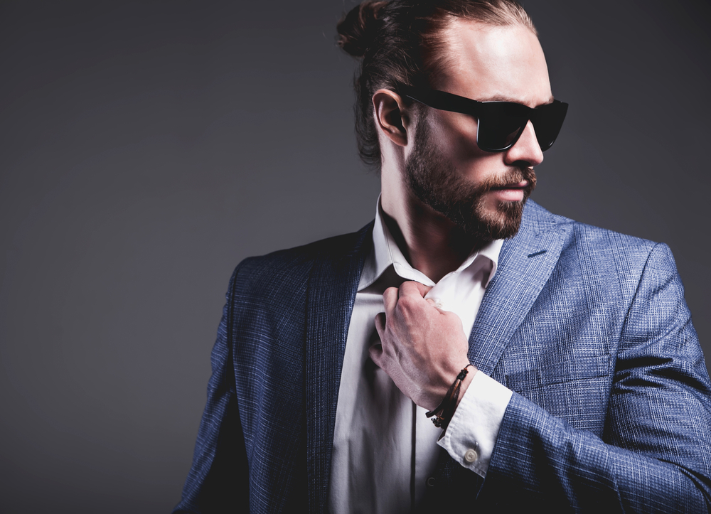 A professional guy wearing a messy man bun (i.e., dude bun) styled with organic hair products and natural oils.