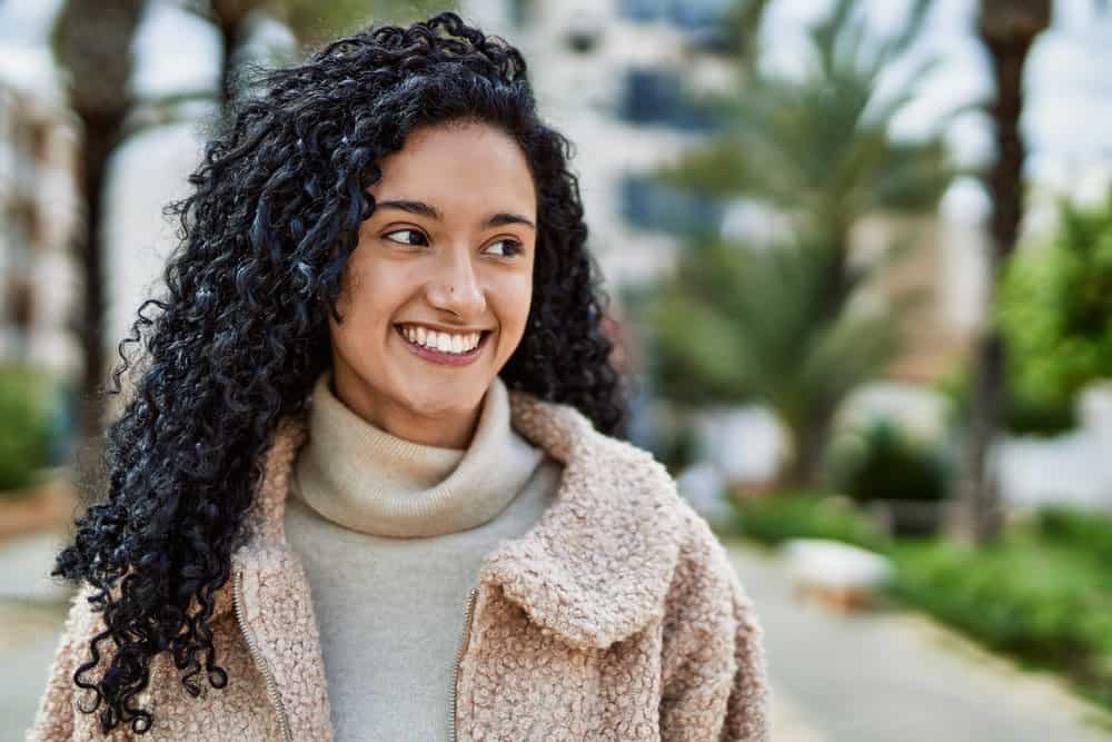 A beautiful Mexican female is wearing a nice unicorn wolf cut style secured on the left side with Ouchless hair ties.