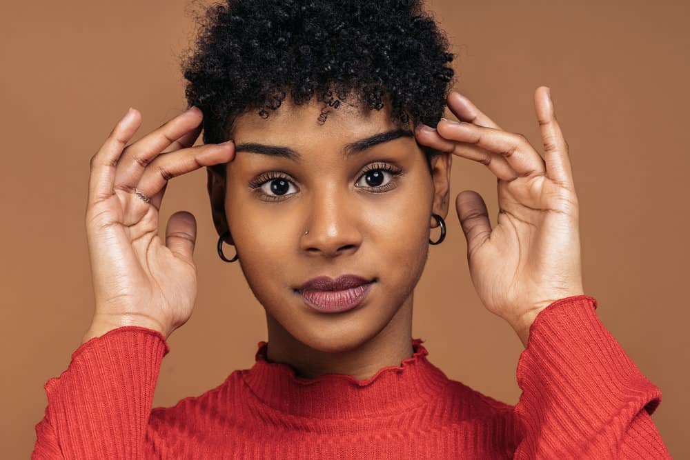 A cute black lady with an itchy scalp has been using an anti-dandruff shampoo with original therapeutic formula.