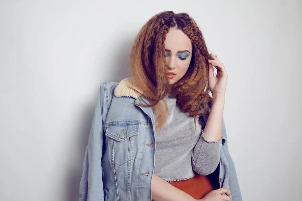 How to Crimp Hair With and Without a Crimper: Step-By-Step 7 A girl with voluminous brushed hair has tight crimps after braiding her long hair, starting with the top half.