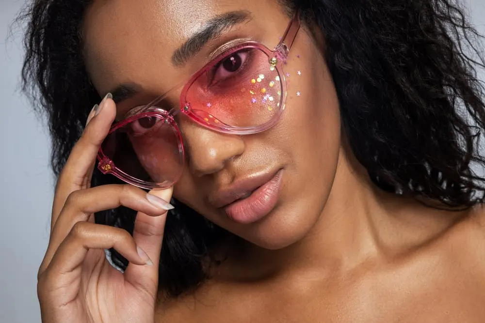 How Often Should You Use a Hair Mask Treatment on Curly Hair 8 African American female with thick hair uses a hair dye brush to apply hair masks to her naturally curly locks.