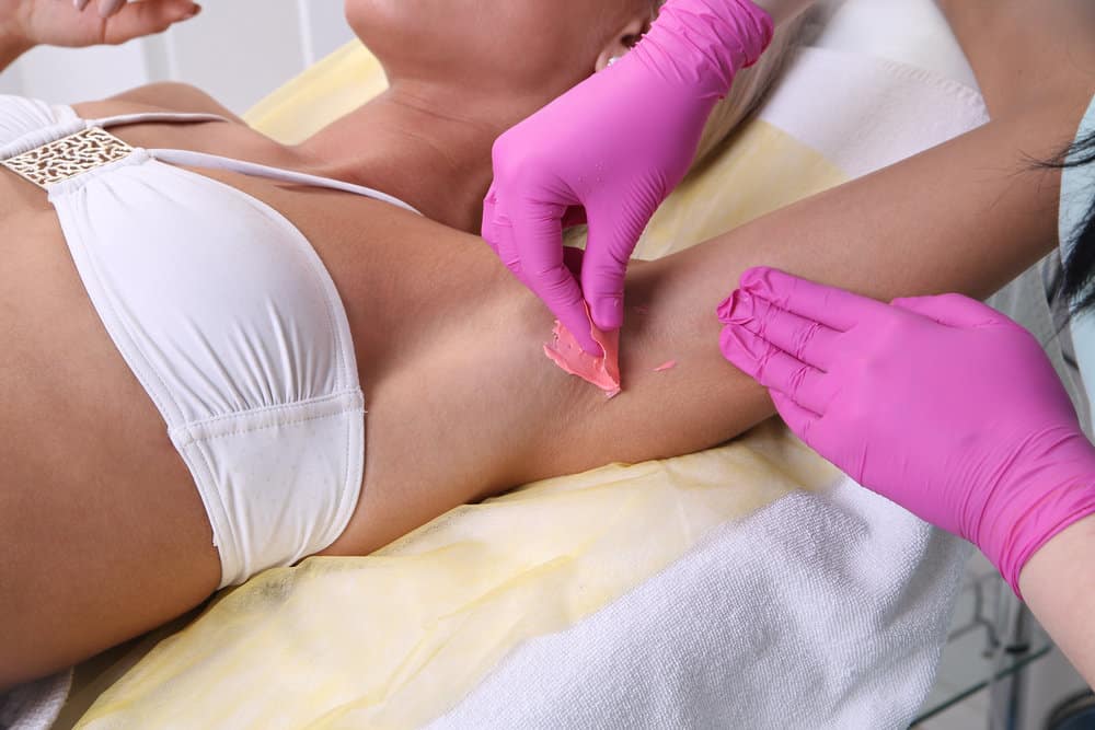 A lady attending one of her monthly waxing appointments to remove armpit hair, leg hair, and hair from the bikini area.