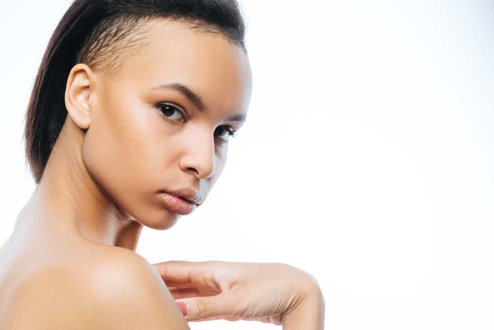 A beautiful woman is wearing her hair long with the middle section looking like a mohawk in a tapered look mullet.