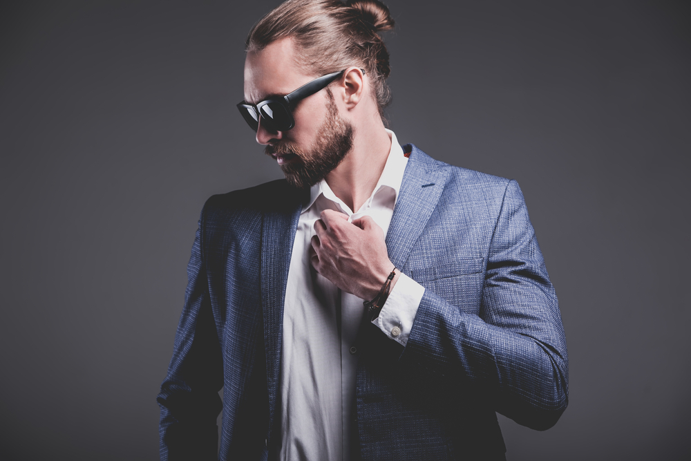 A businessman wearing a half-up man bun, one of the more popular man bun hairstyles for a straight hair type.