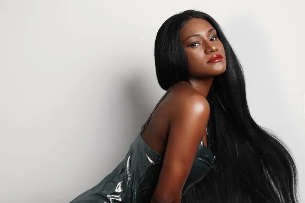 How Much Is a Sew-in Weave Hairstyle Installation? 3 A dark-skinned female is wearing straight hair extensions made from virgin hair installed by a professional hairstylist.