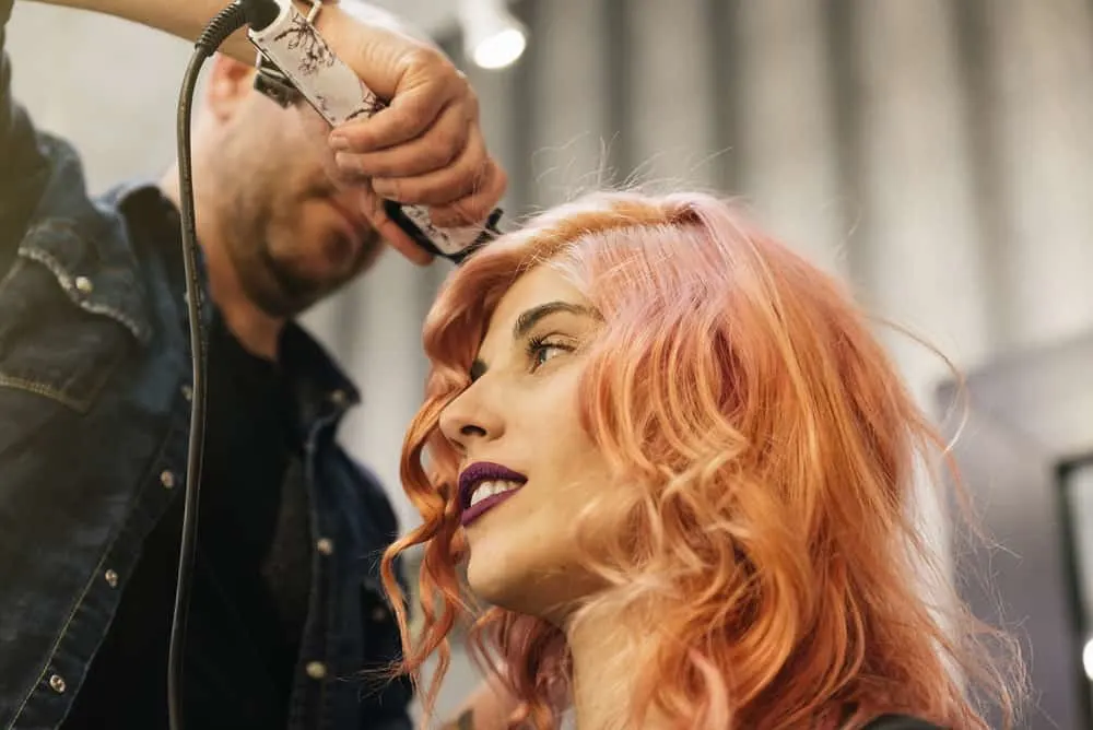 How Much Do Hair Stylists Make a Year, per Day, and Hour 1 A beautiful woman is getting her hair done by a hair stylist at a cosmetology school at a high-end salon.