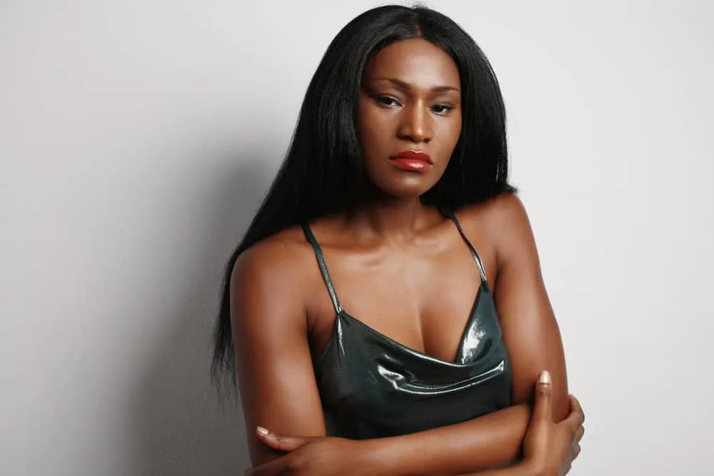 How Much Is a Sew-in Weave Hairstyle Installation? 1 A black woman is wearing long sew-in hair extensions made from Remy hair creating a more natural look.