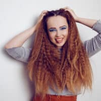 Girl with a voluminous crimped hair look created on slightly damp hair with a curling iron on type 1C straight hair.
