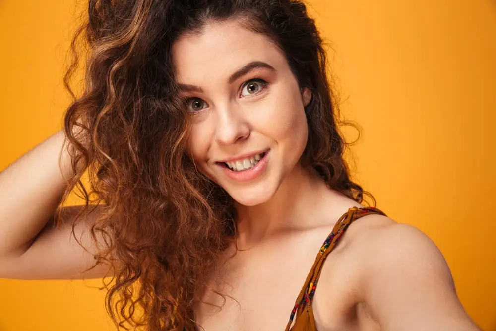 How to Get Messy-Looking Hair for Girls & Guys: Step-By-Step 1 A cute white girl with a messy hairstyle on medium-length hair styled with natural oils and organic styling products.