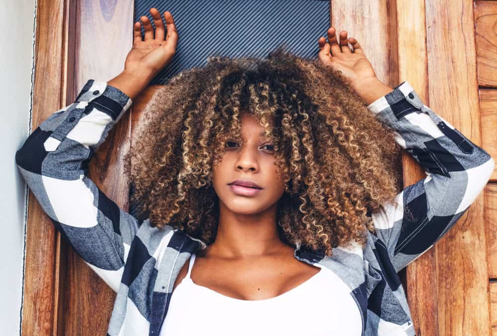 African American female that is wondering how often to cut curly hair during a normal hair care maintenance regimen.