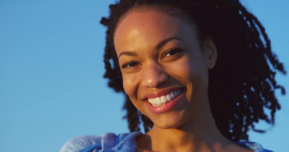 A black lady wearing a two-strand twist protective style after getting her hair twisted by a natural hair stylist.