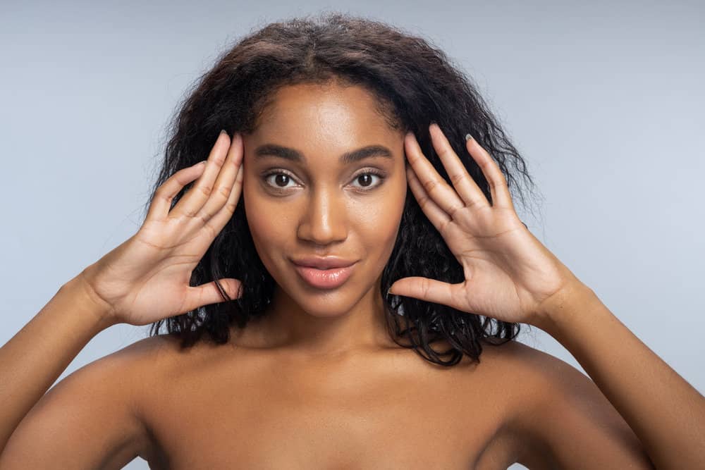 A gorgeous female with naturally curly hair styled with natural oils and treated with an everyday conditioner.