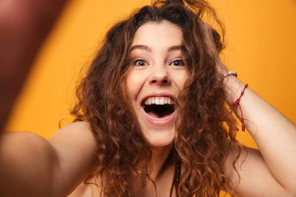 How to Get Messy-Looking Hair for Girls & Guys: Step-By-Step 11 A joyful female with beautiful skin just woke up with her hair a mess with much more body than normal.