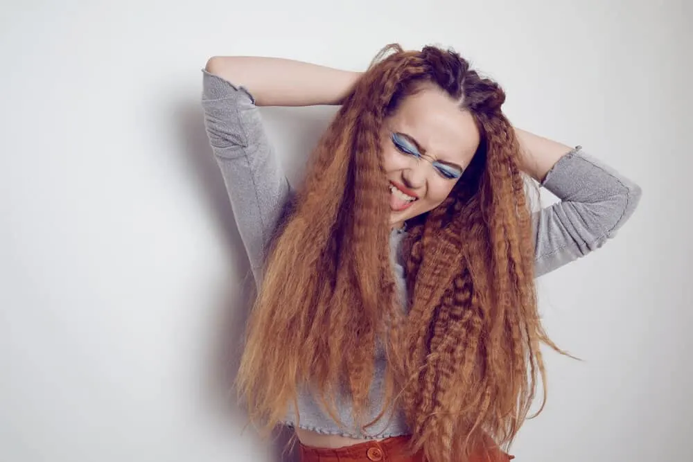 How to Crimp Hair With and Without a Crimper: Step-By-Step 5 A cute white girl with tangle-free straightened hair is creating a crimped look with a flat iron for more volume.