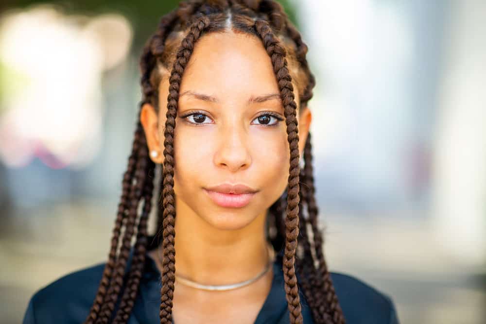 A cute black female is wearing Fulani brands on her 4A natural hair type, which is a great protective style for summer.