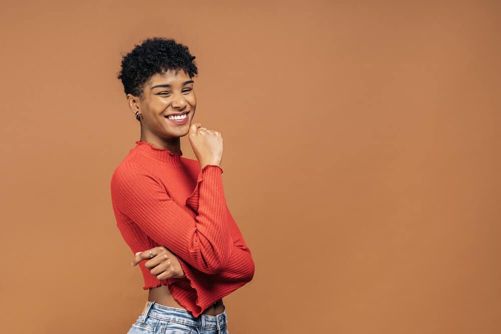 A black girl with silky smooth skin has been using an effective dandruff shampoo to eliminate scalp flaking.