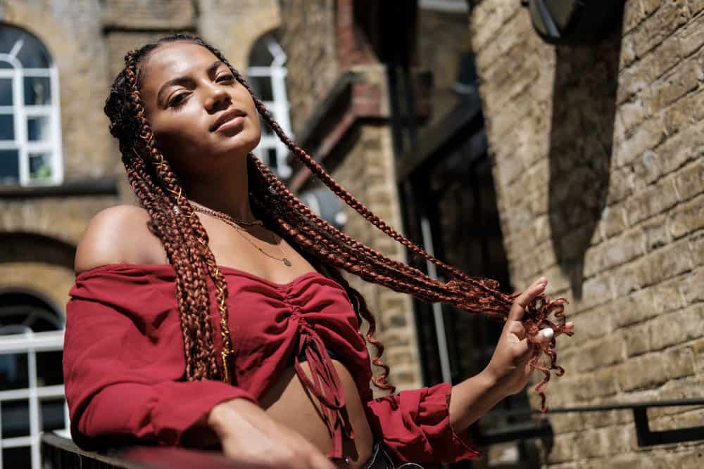 A black lady with braided natural hair in unique box braids colored with a medium-brown Manic Panic hair dye.