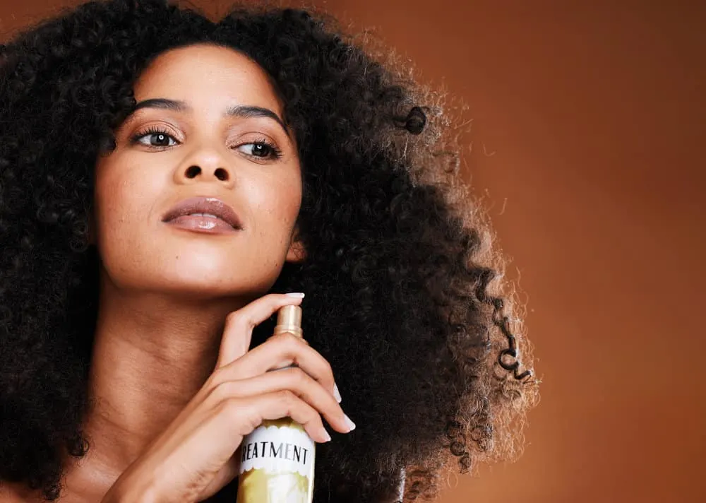 What Is Conditioner Used For? Is It Needed? What Does It Do? 8 A lady with type 3 curls styled with a wide tooth comb and deep conditioning hair masks to reduce split ends.