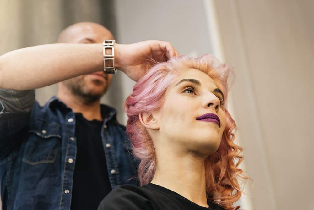 A beautiful female with naturally blonde hair just had her hair colored pink using Manic Panic hair dye.