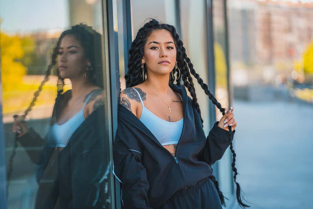 Female with long braids has a simple hair care routine - pre-poo weekly and mist hair to moisturize with water and oils.