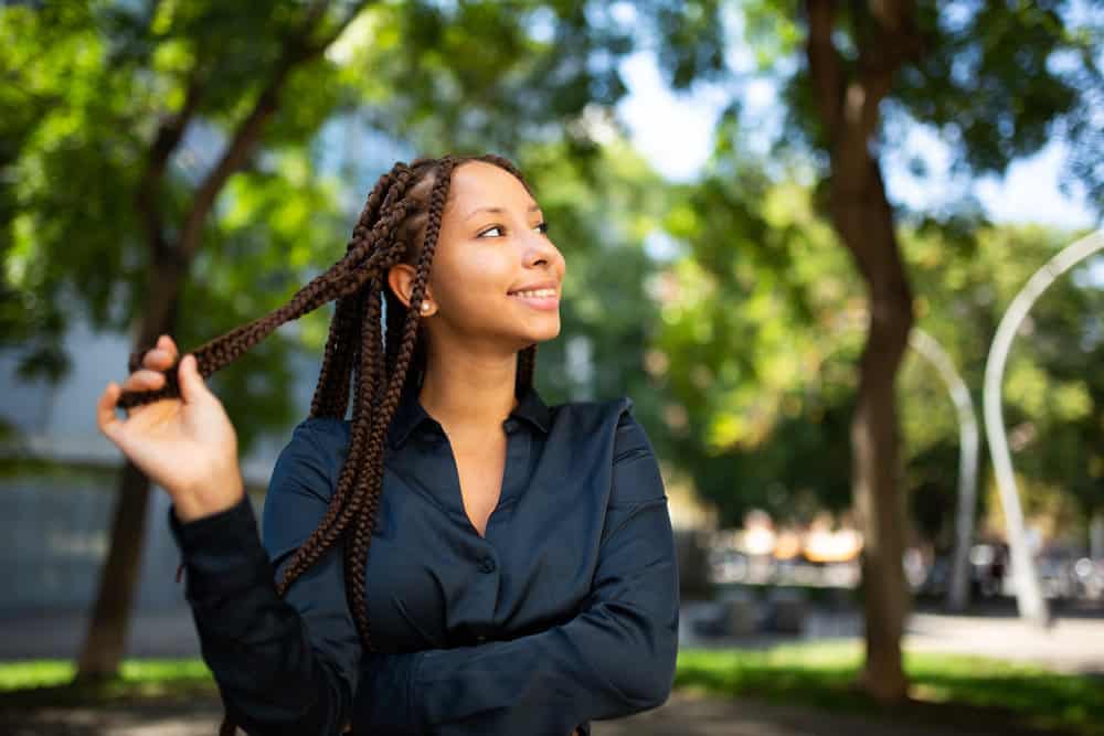 An African American female wearing braided passion twists with her baby hairs styled flat against her forehead.