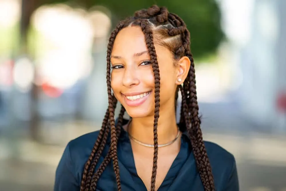 The 10 Best Summer Protective Hairstyles for Natural Hair 12 A black girl is wearing box braids with her baby hair slicked against her forehead with an attractive Nike-like swosh.