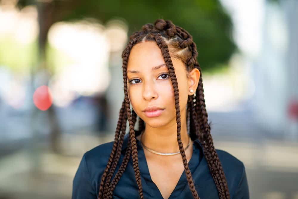 Confident female with new low-maintenance passion braids standing outside in record-breaking heat.