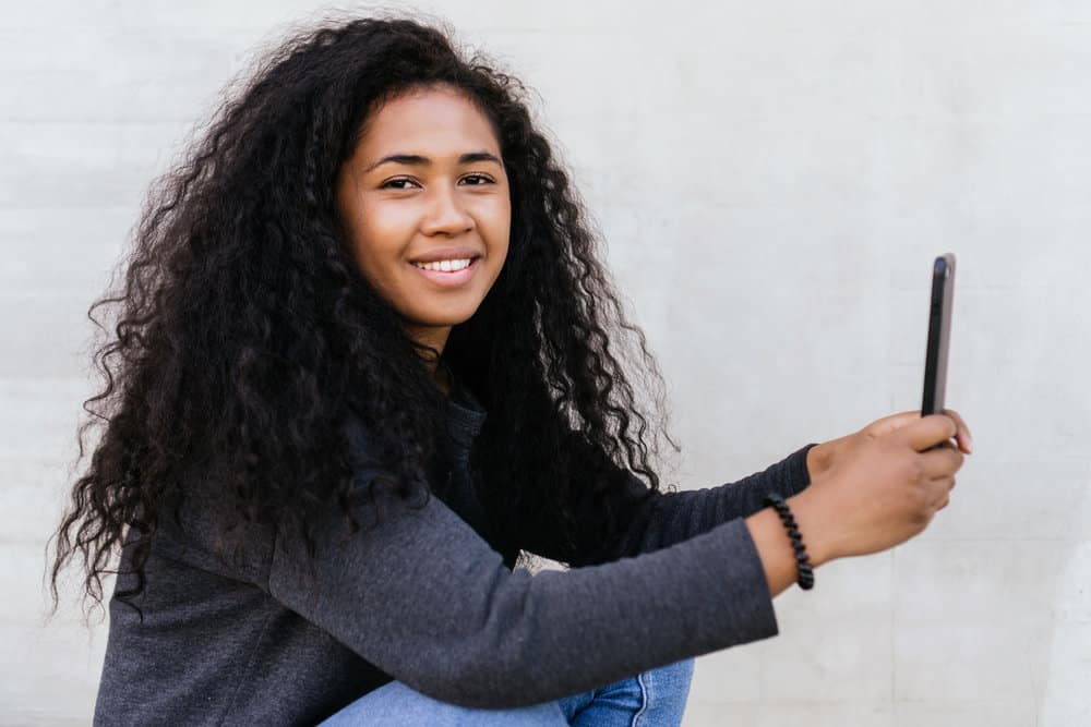 A young black girl with a type 3 hair texture has curly and wavy hair due to her unique natural curl pattern.