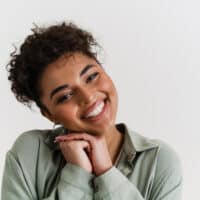 A happy young black girl used makeup remover to gently rub leftover hair dye off her skin quickly.