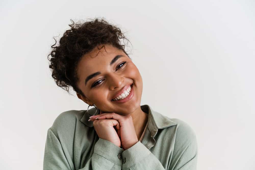 A happy young black girl used makeup remover to gently rub leftover hair dye off her skin quickly.