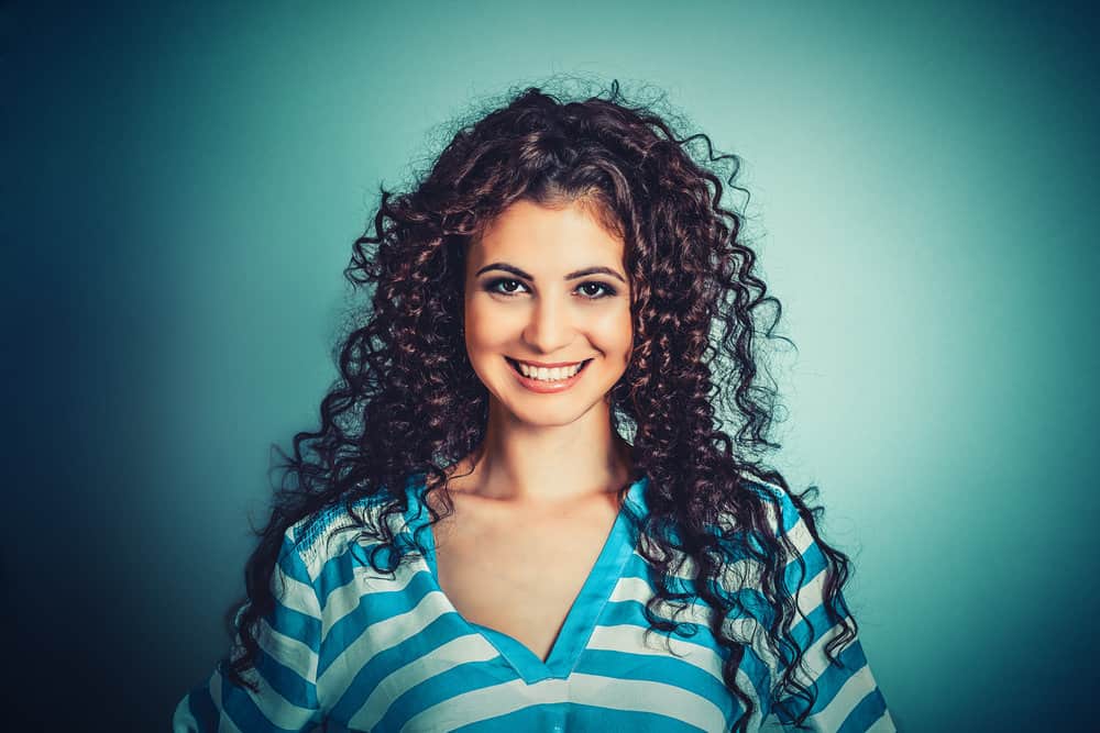 A Caucasian female with ringlet curls on dry hair strands created with thin socks and an ouchless hair tie.