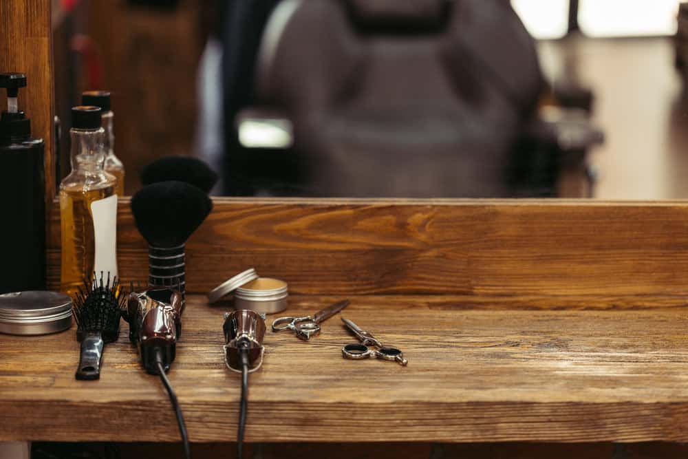 A local barber with dull hair clippers takes a photo before preparing to sharpen blades and clean his tools.