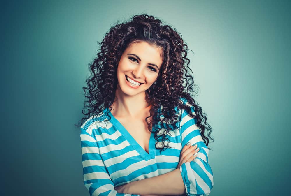 A stylish young female with a great smile tried a new style with her hair wrapped around socks to create beautiful curls.