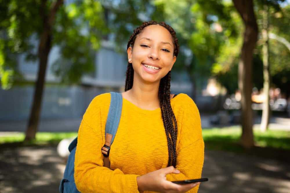 A young black girl is researching ways to style dookie braids and other braiding styles with hair accessories.