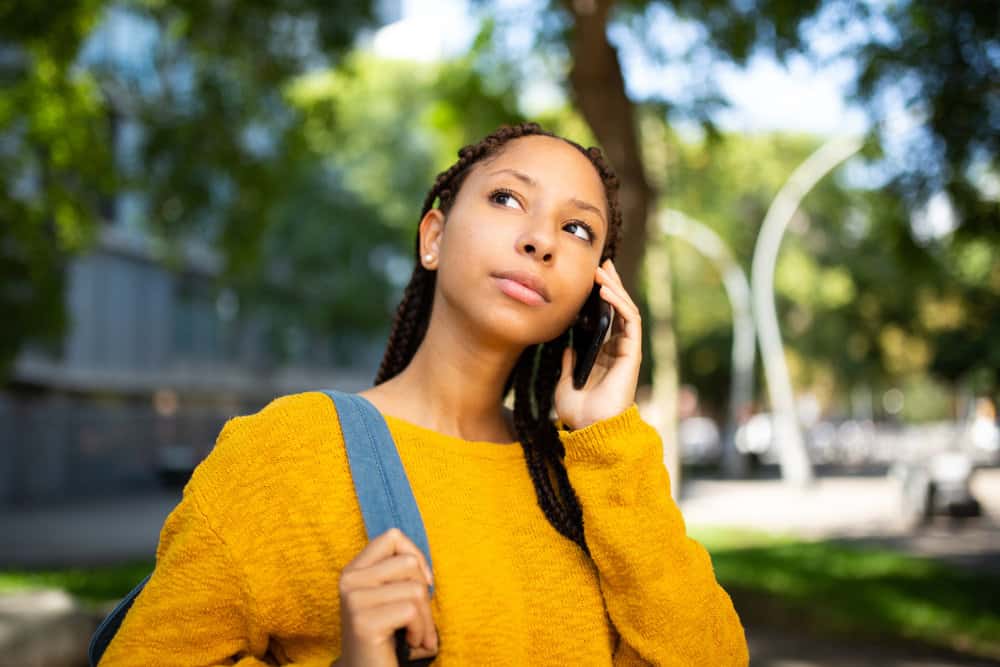 A cute black girl allows her black braids to hang freely, allowing her to create different styles with the long braids.