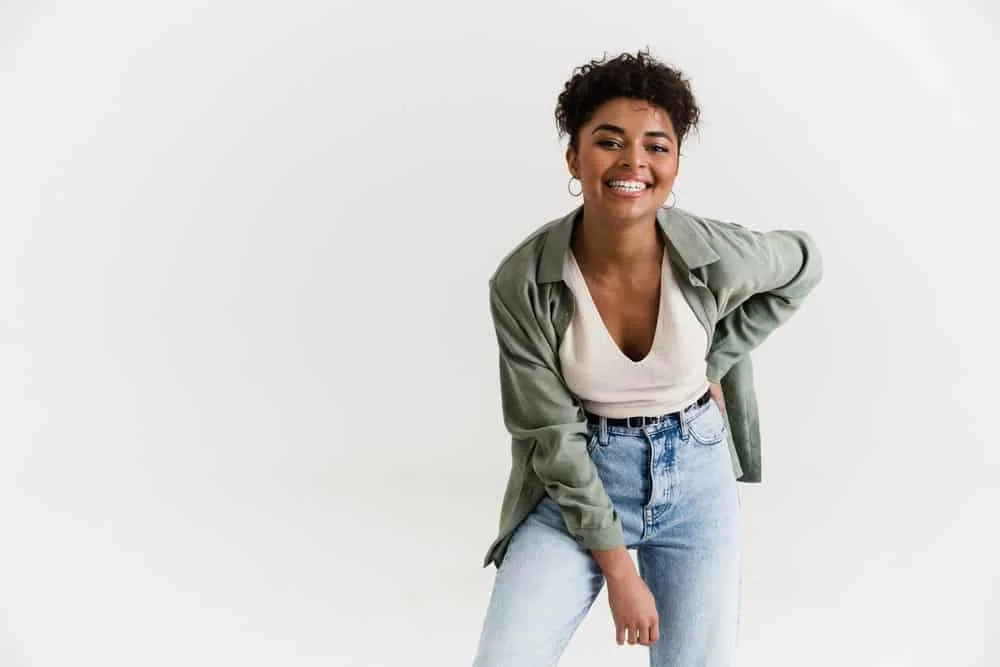 Can Micellar Water Remove Hair Dye From Skin? All Skin Types? 5 A black girl is wearing a casual outfit and laughing during a playful time with family and friends.