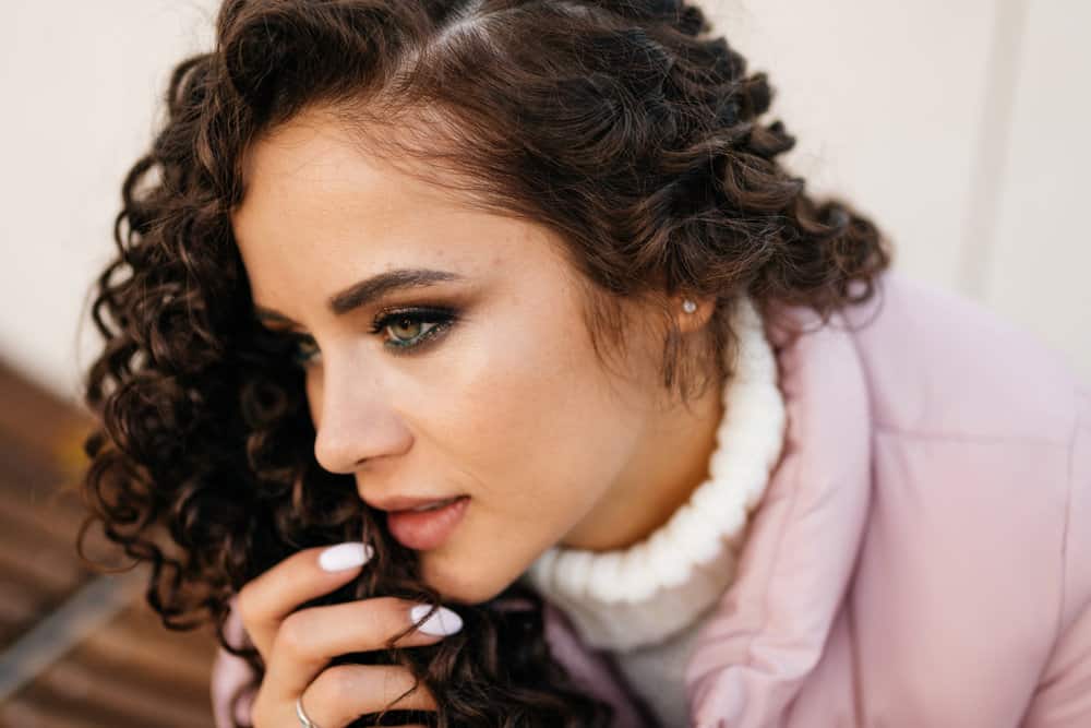 A stylish young female with permed hair after using digital perm rods to create curls and soft waves.