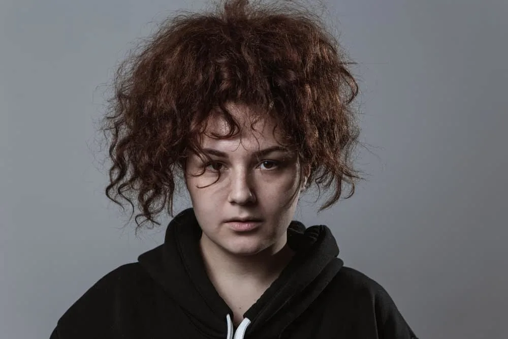 How to Fix Dead Hair Follicles at Home Without Cutting It 4 A woman with frizzy hair was recently washed with a shampoo and conditioner and styled with a leave-in conditioner.