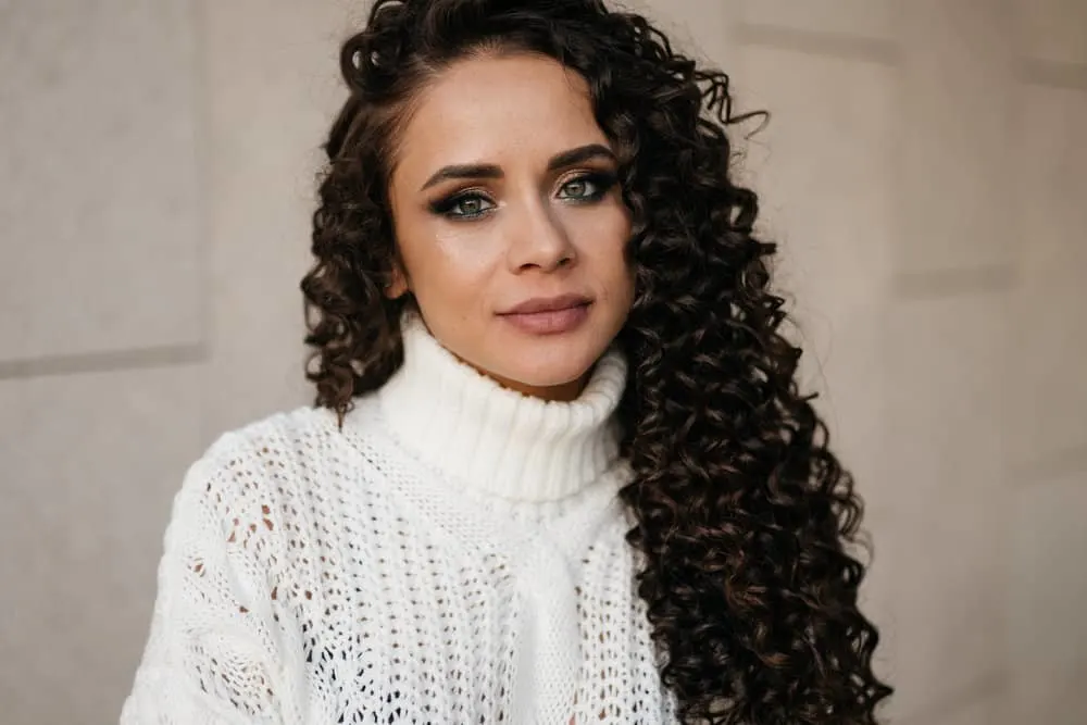 How Much Does a Perm Cost for Girls and Guys at a Salon 5 A beautiful tanned female is wearing an alkaline perm on thinning hair creating voluminous soft waves.
