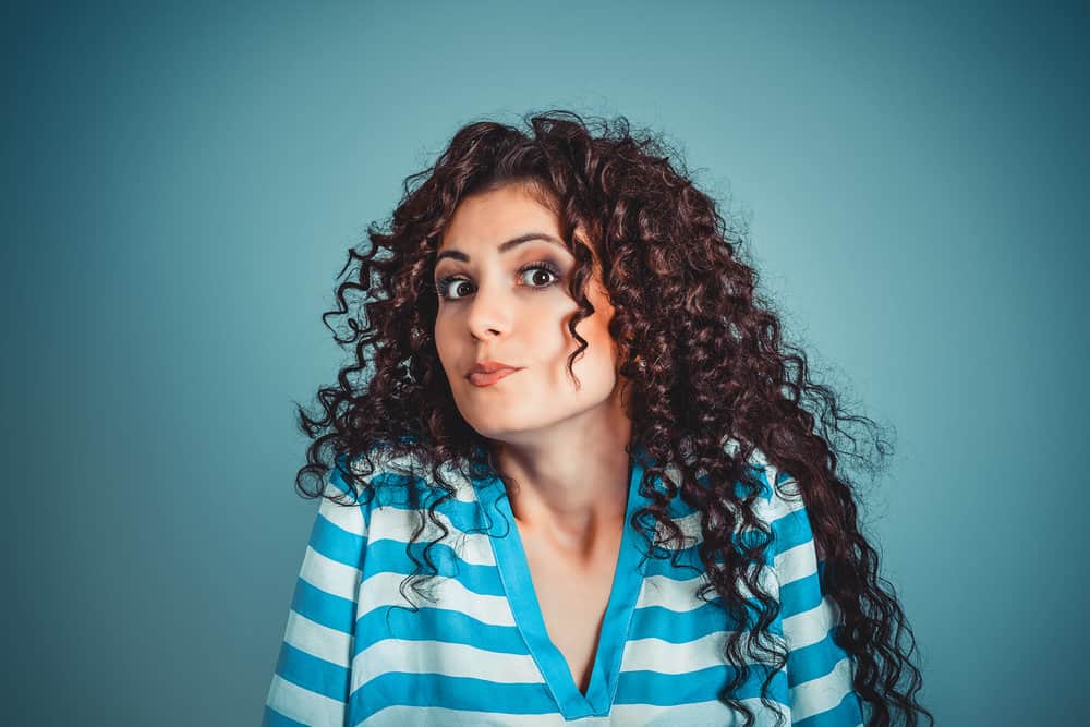 A female with damp strands after using a spray bottle to enhance her heat-free sock curls and voluminous waves.