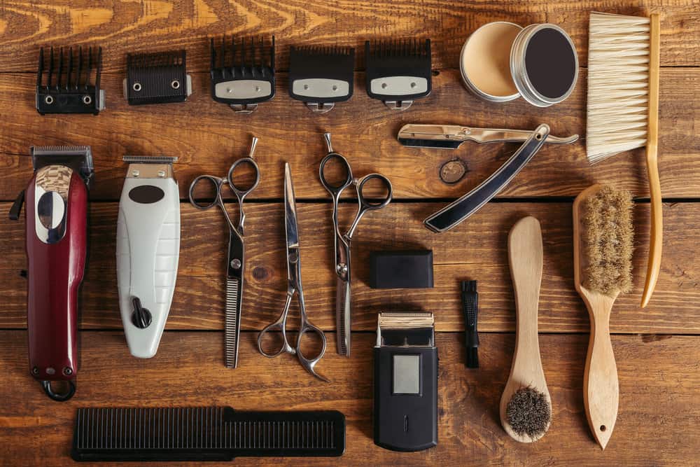 Equipment from a local barber showing hair clipper blades, guards, a comb blade, and blade wash solution.