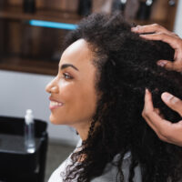 A lady in a salon chair receiving excellent service is wondering how much to tip hairdressers for multiple salon services.