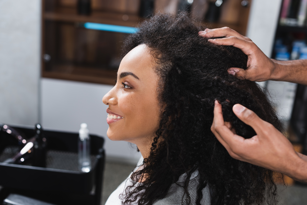 A lady in a salon chair receiving excellent service is wondering how much to tip hairdressers for multiple salon services.