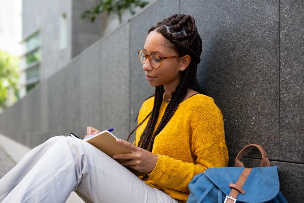 A young African lady with a dookie braid style (i.e., large braids) only differing from regular box braids due to size.