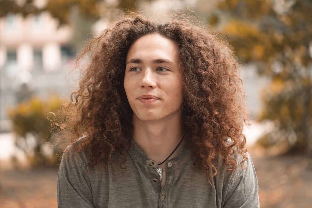 A guy with naturally straight hair used a crimping tool to create his stylist wolf haircut.