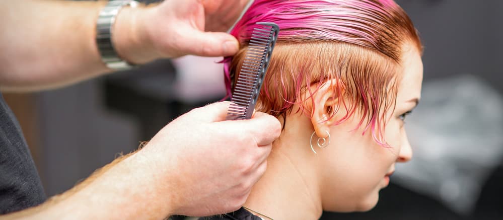 A female has her hair professionally dyed with hair color containing harsh chemicals.