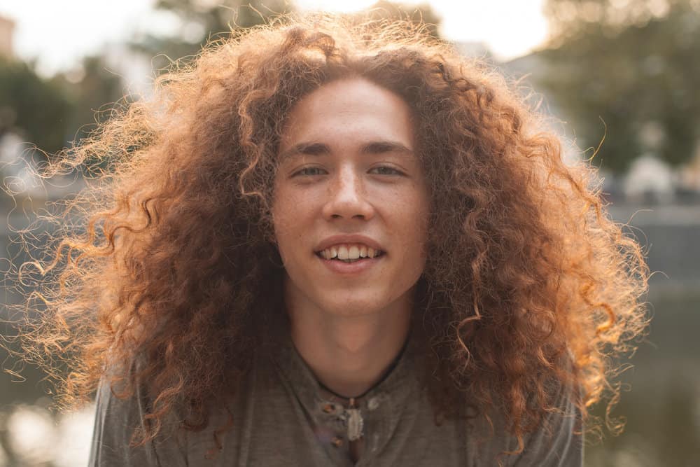 A man with natural curtain bangs after growing out his short hair into a nice long wolf hairstyle.