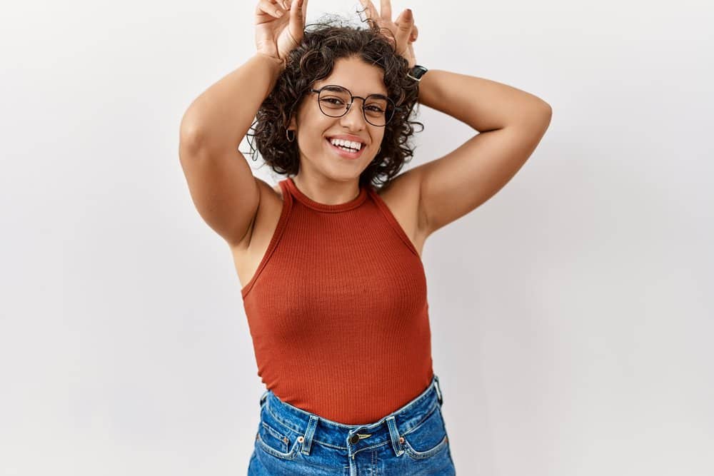 A cute native American female from Latinx culture is wearing her naturally curly hairstyle.