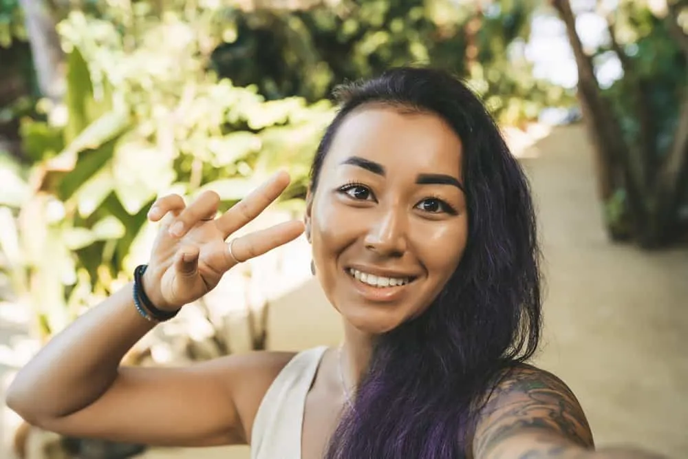 Is Redken a Good Brand for Your Hair or Is It Bad for Curls? 3 Asian female with a great smile has chemically lightened hair that's been treated with purple shampoo.